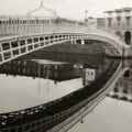 black and white photograph of the Ha'pennt bridge in Dublin early in the morning with no people