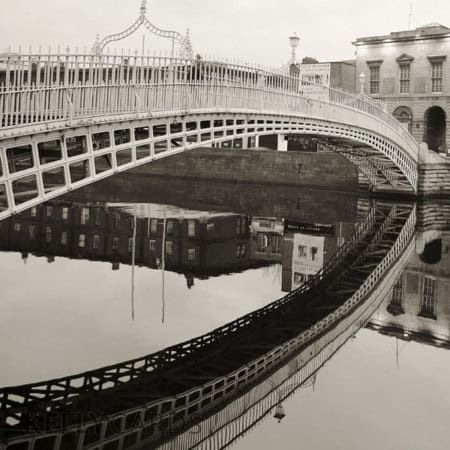 black and white photograph of the Ha'pennt bridge in Dublin early in the morning with no people